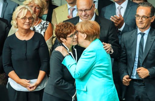 Nach der Vereidigung wird Annegret Kramp-Karrenbauer (li.) von Kanzlerin Angela Merkel beglückwünscht. Wirtschaftsminister Peter Altmaier schaut zu. Foto: AFP