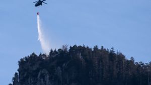 Ein Hubschrauber fliegt am 2. Januar in Kochel am See (Bayern) über dem Kochelsee. Ein Bergsteiger hatte am Jochberg einen Flächenbrand ausgelöst. Rund hundert Hektar Wald und Wiese standen in Flammen, die Löscharbeiten könnten nach Angaben des Landratsamtes noch Tage dauern. Foto: dpa