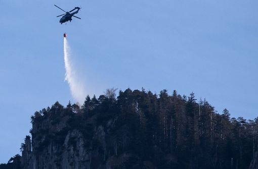 Ein Hubschrauber fliegt am 2. Januar in Kochel am See (Bayern) über dem Kochelsee. Ein Bergsteiger hatte am Jochberg einen Flächenbrand ausgelöst. Rund hundert Hektar Wald und Wiese standen in Flammen, die Löscharbeiten könnten nach Angaben des Landratsamtes noch Tage dauern. Foto: dpa