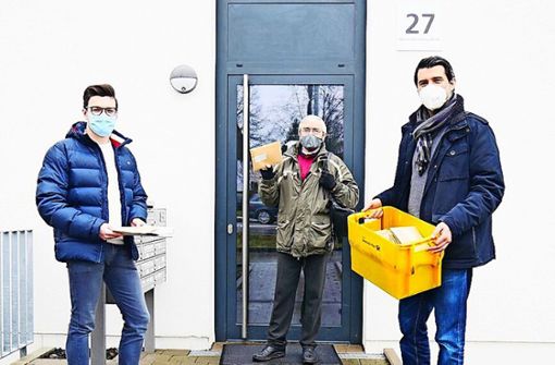 Bruno Authaler (Mitte) vom  Arbeitskreis Asyl sowie Valentin Flesch und  Kadir Koyutürk von der Stadt Kornwestheim   verteilen in der Unterkunft an der Werner-Heisenberg-Straße medizinische Masken. Foto: z