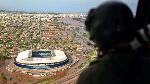Ein Soldat betrachtet vom Helikopter aus das überflutete Fußballstadion von Porto Alegre. Foto: AFP/Carlos Fabal