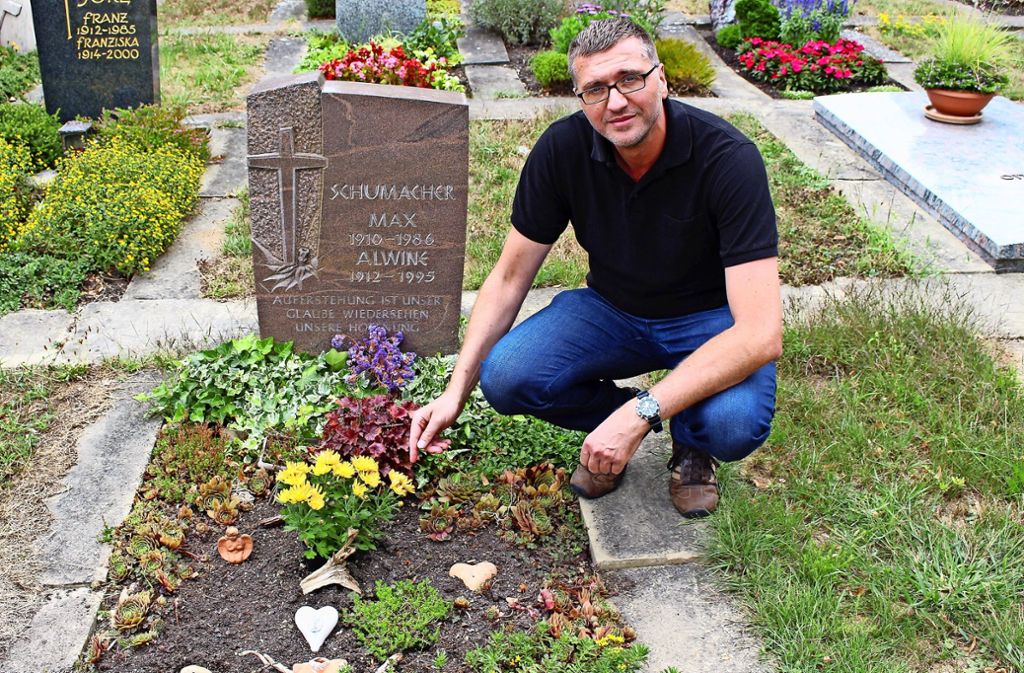 Frank Laux am Grab seiner Großeltern. Die Blumen, die mittig saßen, sind zerstört worden. Foto: Caroline Holowiecki