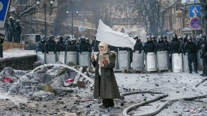 Eine einsame Demonstrantin in Kiew steht in einem Trümmerfeld. Foto: dpa