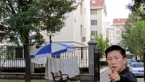 Ein Sicherheitsbeamter weist Journalisten vor dem abgeriegelten Haus von Liu Xia, der in Peking unter Hausarrest stehenden Frau des Friedensnobelpreisträgers Liu Xiaobo an, keine Fotos zu machen. Foto: dpa