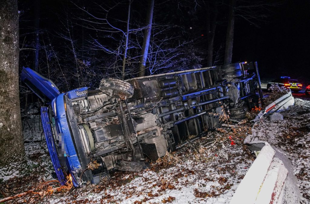 Ein schwerer Laster ist bei schneeglatter Fahrbahn verunglückt und umgekippt.