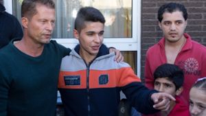 Der Schauspieler Til Schweiger (links) steht am 30. September vor einem Flüchtlingshaus in Osnabrück neben Flüchtlingen. Schweiger will sich mit seiner «Til Schweiger Foundation» für Flüchtlings-Kinder einsetzen. Foto: dpa