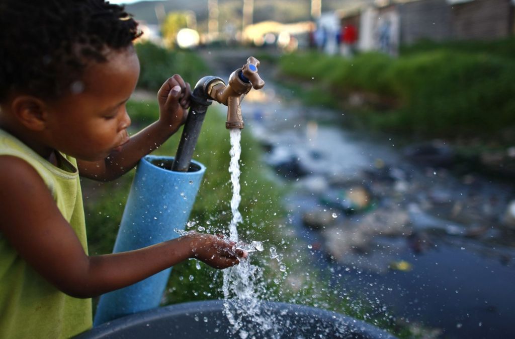 Ein Junge trinkt aus einer kommunalen Quelle in Kapstadt. Seit Monaten sind die Bewohner der südafrikanischen Metropole zum strengen Wassersparen angehalten. Foto:  