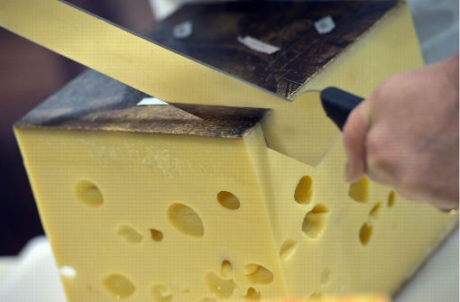 Beim größten Käsetest Europas schneidet ein Experte in Trier einen Emmentaler Käse. Foto: dpa
