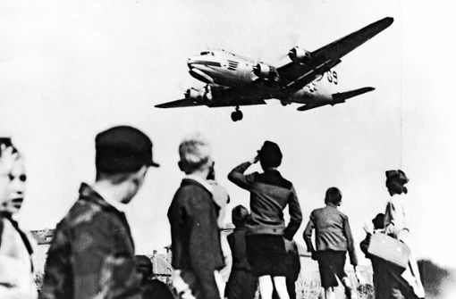 Ein US-“Rosinenbomber“ beim Landeanflug auf Westberlin: Die Kinder warten auf den Abwurf von Süßigkeiten an Taschentuch-Fallschirmen. Foto: epd