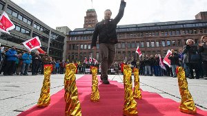 Ein Angestellter der Albert-Ludwigs-Universität Freiburg läuft am Mittwoch in Freiburg bei einer Verdi-Protestaktion über einen symbolischen roten Teppich. Foto: dpa