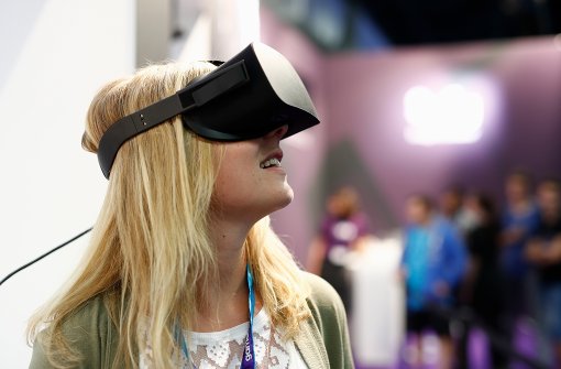 Eine Besucherin der Gamescom 2016 in Köln blickt sich gebannt um, während sie eine „Virtual-Reality“-Brille trägt. Foto: Getty Images