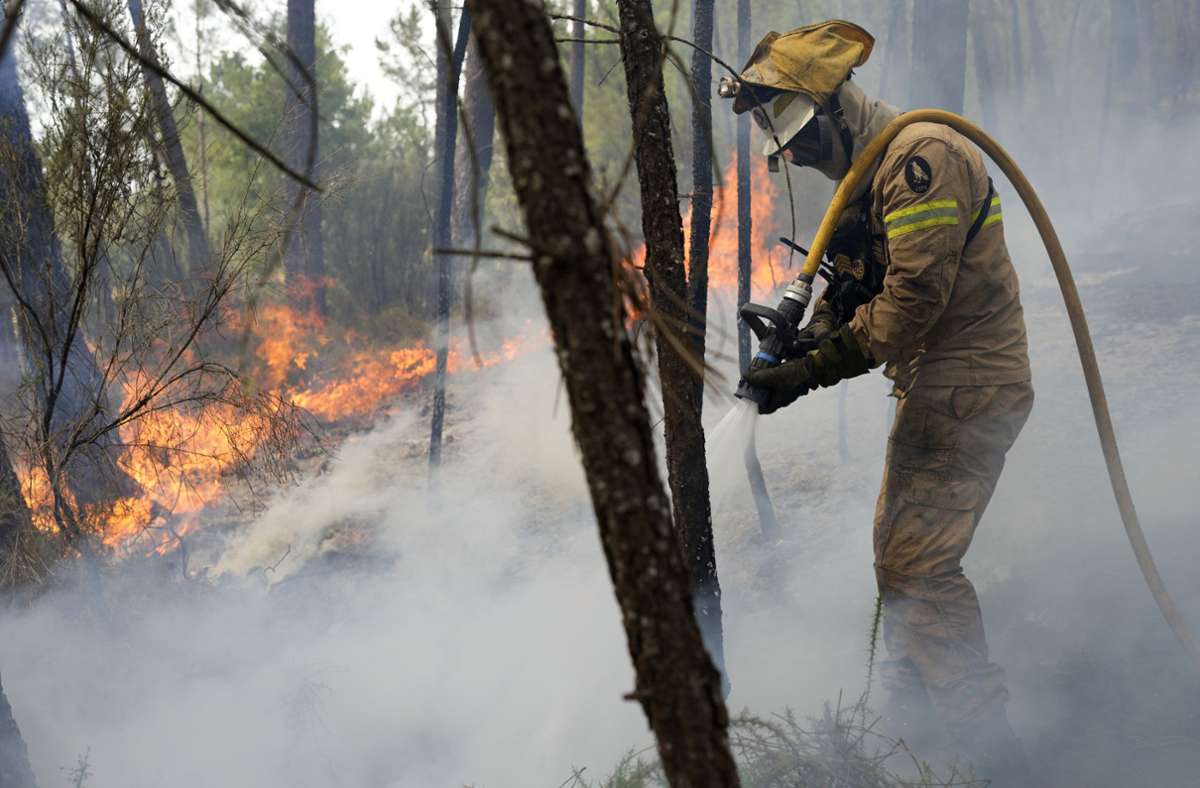 Feuerwehrleute der Nationalen Republikanischen Garde löschen einen Waldbrand in dem Dorf Rebolo in der Nähe von Ansiao in Zentralportugal. Foto: Armando Franca/AP/d/a
