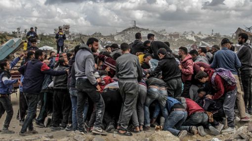 Menschen drängen sich um Pakete mit humanitärer Hilfe, die über dem nördlichen Gazastreifen abgeworfen wurden. Israel hat sofortige Schritte zur Erhöhung humanitärer Hilfe für die Zivilbevölkerung beschlossen. Foto: Mahmoud Issa/dpa