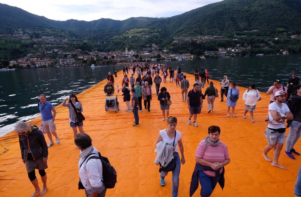 Besucher gehen auf den schwimmenden Stegen vor Paratico auf dem Lago d’Iseo in Italien.