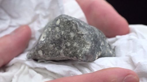 Ein  Meteoritenteil liegt in einem Papiertaschentuch. Das Bruchstück wurde von vier polnischen Meteortitensuchern auf einem Feld bei Ribbeck gefunden. Foto: dpa/Cevin Dettlaff