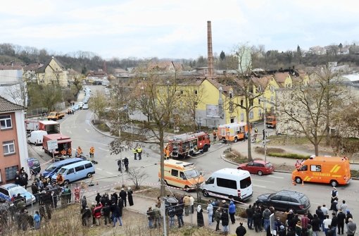 Schaulustige und Rettungskräfte bevölkern den Unglücksort in Backnang: In der alten Lederfabrik (gelbes Gebäude) starben sieben Kinder und deren Mutter. Foto: dpa