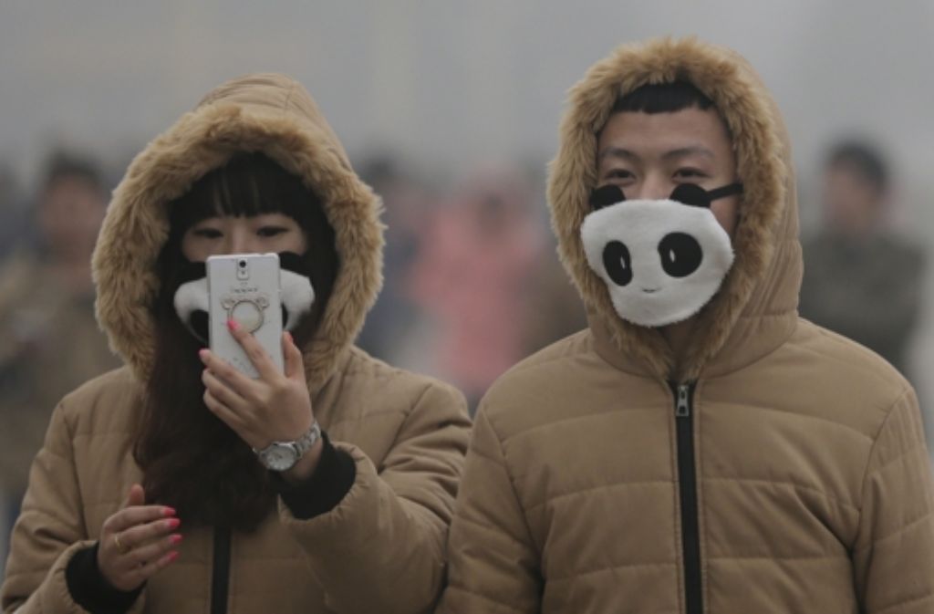 Wenn schon Atemschutz, dann bitte mit modischem Statement. Hier sind es zwei Pandas, die sich vor der schlechten Luft in Peking schützen. Foto: AP