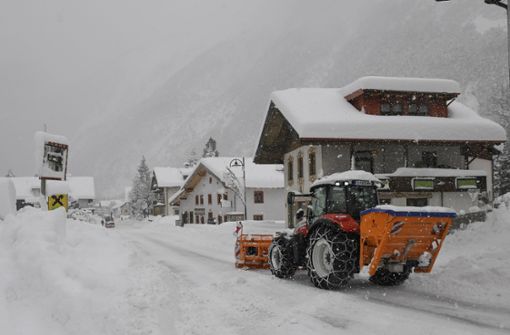 Ein Räumfahrzeug fährt durch den verschneiten Ort Scharnitz. Aufgrund von starken Schneefällen kommt es zu massiven Verkehrsbehinderungen und Straßensperrungen im österreichischen Bundesland Tirol. Foto: Adpa