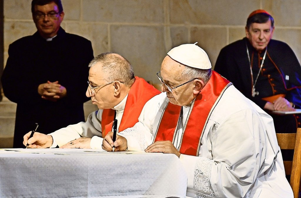 Papst Franziskus (rechts) und der Präsident des Lutherischen Weltbundes, Bischof Munib Younan, unterzeichnen  in der Kathedrale von Lund ein gemeinsames Wort anlässlich des katholisch-lutherischen Reformationsgedenkens Foto: epd