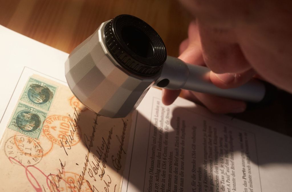 Der 20-jährige Briefmarken-Sammler Kevin Weigt  aus Neuwied in Rheinland-Pfalz betrachtet einen Brief seiner Sammlung, der 1873 von Princeton (Massachusetts) in die Schweiz versendet wurde. Foto: Thomas Frey/dpa