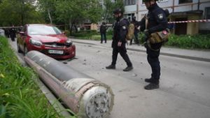 Polizisten inspizieren einen Teil einer russischen Rakete, die in der Nähe eines Wohnhauses in Charkiw eingeschlagen ist. Foto: Andrii Marienko/AP