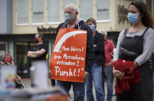 Ein Mann trägt ein Schild mit der Aufschrift: „Man lässt keine Menschen ertrinken! Punkt!“. Foto: Lichtgut/Julian Rettig