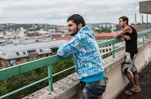 Zwei Männer stehen auf der Terrasse des Martinus-Hauses in Stuttgart. Das Gebäude dient seit dem Wochenende als Flüchtlingsunterkunft. Foto: dpa