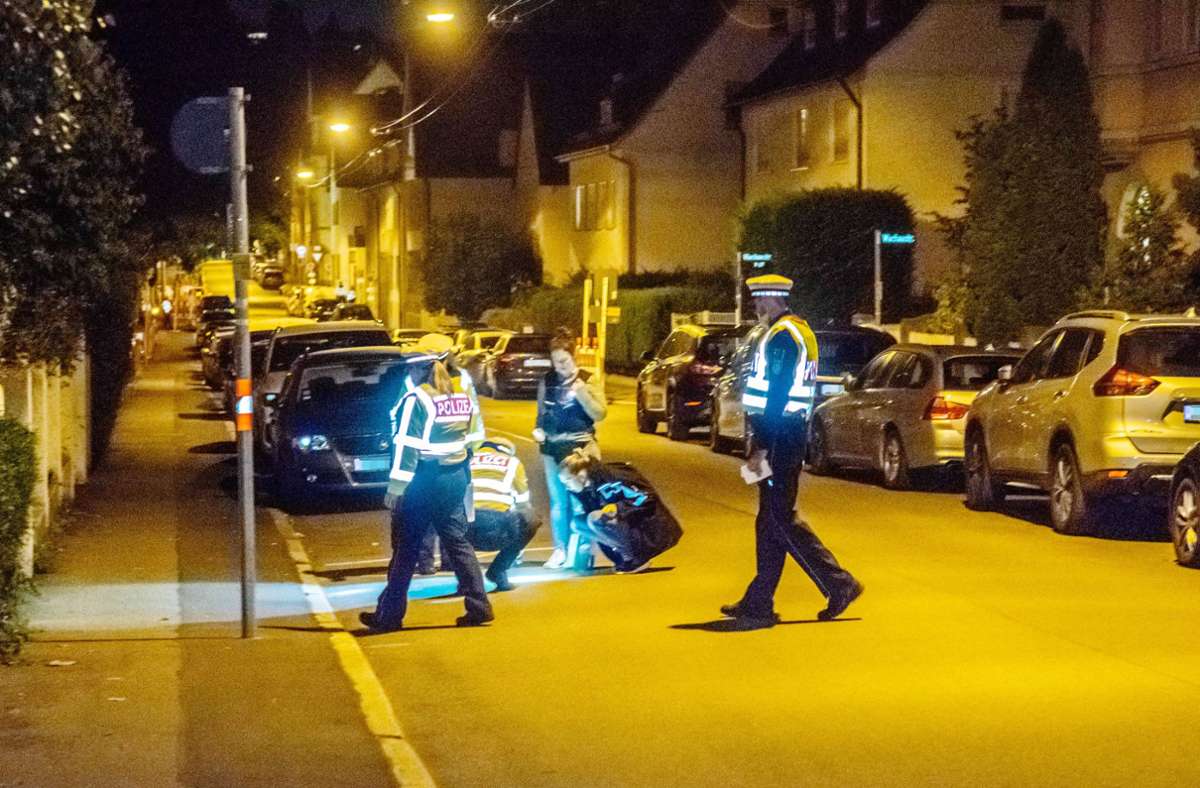 Polizeibeamte suchen am Sonntagabend  im Umfeld des Tatorts in Feuerbach nach Spuren der Bluttat.