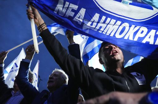 Anhänger der Nea Dimokratia feiern: Die Partei von Ministerpräsident Kyriakos Mitsotakis legte im Vergleich zur Wahl vor vier Jahren deutlich zu. Foto: dpa/Petros Giannakouris