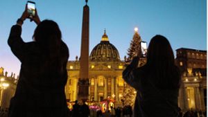 Besucher fotografieren auf dem Platz vor dem Petersdom in Rom die Weihnachtskrippe. Foto: imago/Matteo Nardone