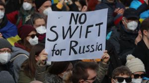 Bei einer Demonstration in Frankfurt hält eine Frau ein Schild mit der Aufschrift „No Swift for Russia“. Foto: AFP/YANN SCHREIBER