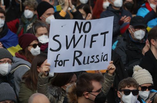 Bei einer Demonstration in Frankfurt hält eine Frau ein Schild mit der Aufschrift „No Swift for Russia“. Foto: AFP/YANN SCHREIBER