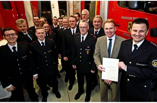 Kommandant Timo Günther (rechts) und Bürgermeister Ralf Trettner  gratulieren den Feuerwehrleuten  zu  ihren Ehrungen und Beförderungen. Foto: Frank Wittmer