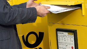 Ein Mann wirft Post in einen Briefkasten Foto: dpa