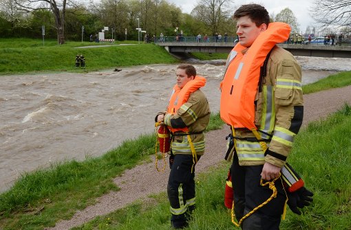 Feuerwehrmänner suchen in Freiburg die Dreisam nach starken Regenfällen nach einem gekenterten Kanufahrer ab. Foto: dpa