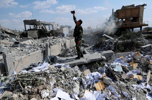 Ein syrischer Soldat filmt die Schäden an einer Anlage, die von der US-geführten Allianz bei dem Angriff zerstört worden ist. Foto: AP