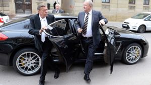 Der ehemalige Vorstandsvorsitzende der Porsche Automobil Holding SE, Wendelin Wiedeking (rechts), steigt zusammen mit seinem Anwalt Hanns Feigen (links) auf dem Weg zum Landgericht in Stuttgart (Baden-Württemberg). Foto: dpa