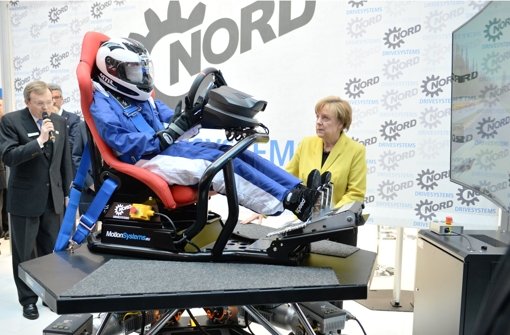 Bundeskanzlerin Angela Merkel schaut sich beim Eröffnungsrundgang der Hannover-Messe bei der Firma Nord Drivesystems einen Kartsimulator an. Foto: dpa