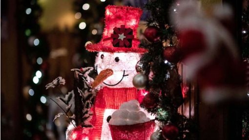 Ein von innen beleuchteter Deko-Schneemann steht im Flur der weihnachtlich dekorierten Wohnung Foto: Fabian Strauch/dpa
