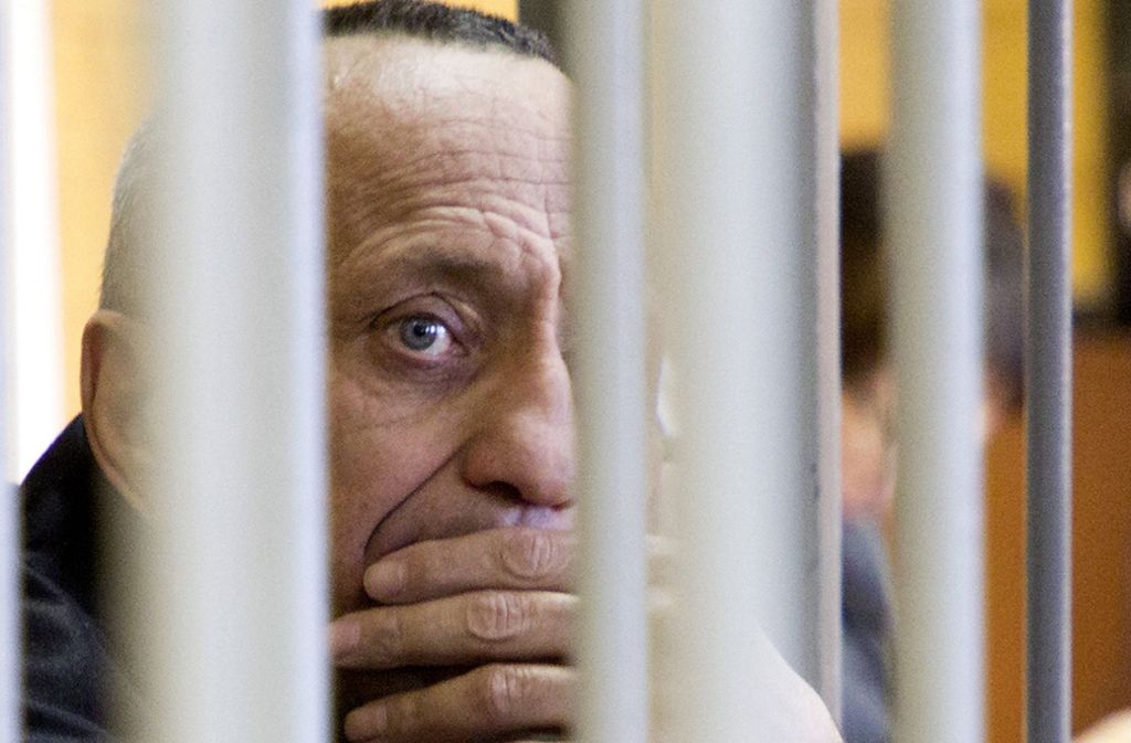 Michail Popkow sieht während der Gerichtsverhandlung durch die Käfigfgtter. Ein Gericht in Irkutsk hat  den 53-Jährigen des Mordes an weiteren 56 Frauen schuldig gesprochen und ihn zu einer lebenslangen Haftstrafe verurteilt. Foto: dpa