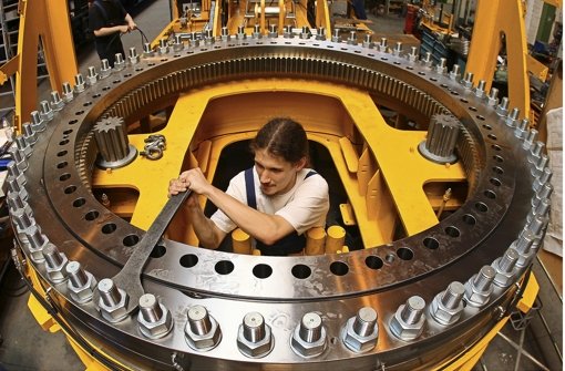 Maschinenbau in Deutschland: Techniker fixiert ein Maschinenteil – geplant wurde es von Ingenieuren. Deren Beschäftigung hat 2013 einen Höchststand erreicht. Foto: dpa-Zentralbild