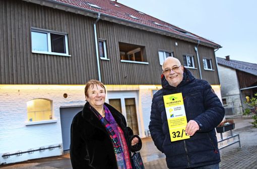 Dorothea und Wilfried Veeser mit dem Hausnummernschild, das ihren Neubau als vorbildhaftes „Klimahaus“ ausweist. Foto: Ines Rudel