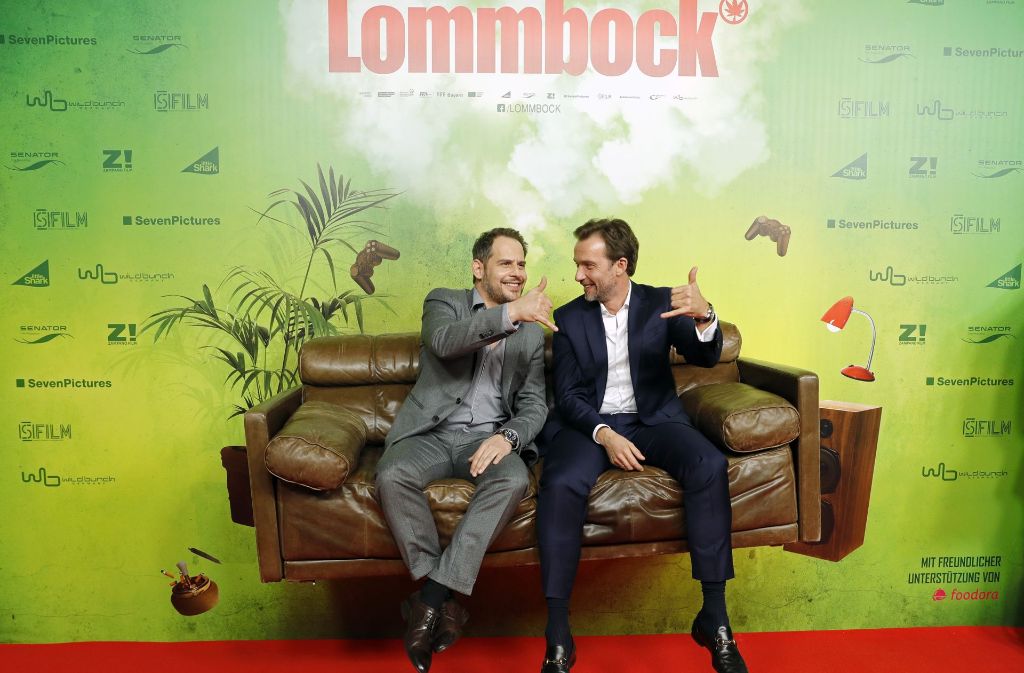 Moritz Bleibtreu (links) und Lucas Gregorowicz sitzen bei der Premiere ihres Films „Lommbock“ auf einem schwebenden Sofa.