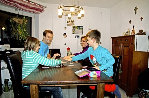 Au-pair Kyle Blomquist (Zweiter von links) ist voll in die Familie Rieger integriert. Nicht nur beim Kartenspiel am Küchentisch haben  Hannes, Mutter Tanja und Jakob (von rechts) viel Spaß mit dem jungen  Mann aus den USA. Foto: Sabine Rochlitz