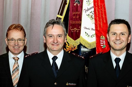 Bürgermeister Ralf Trettner (links) und der neue Feuerwehrchef Timo Günther (rechts) nehmen den scheidenden Kommandanten Frank Holzwarth in die Mitte. Foto: Frank Wittmer