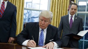 Donald Trump unterzeichnet das Dekret zum Ausstieg aus dem Freihandelsabkommen TPP. Foto: AP