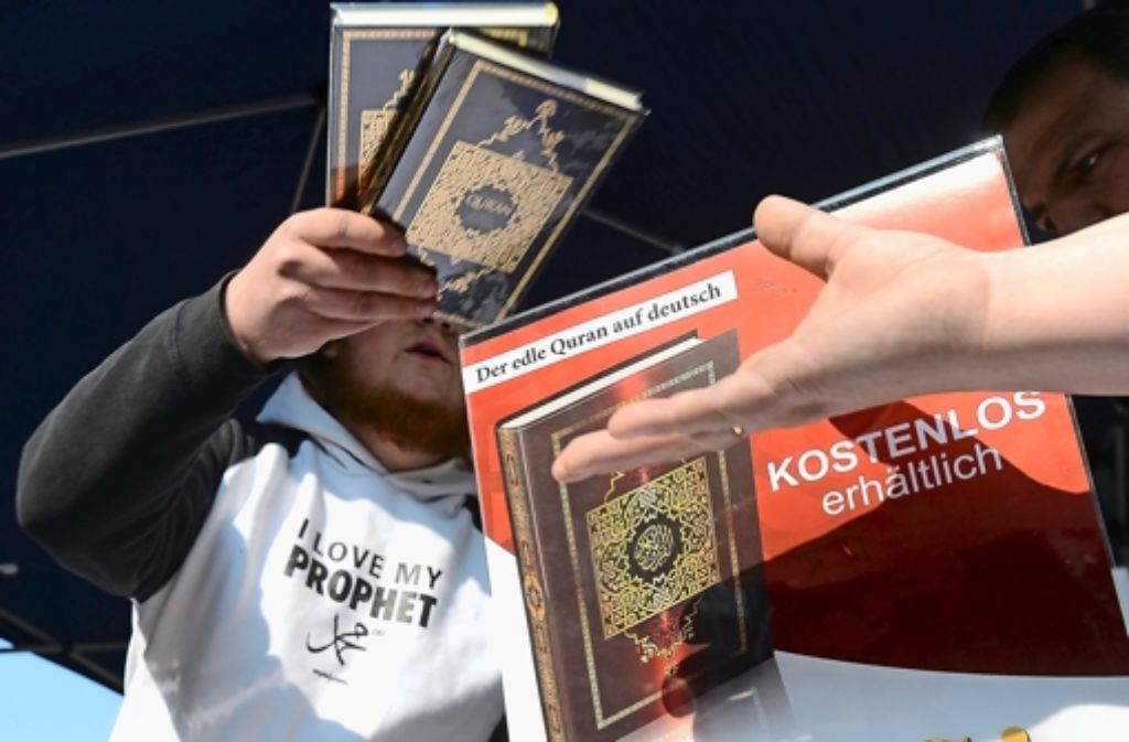 Ein Mann verteilt in der Innenstadt von Hannover kostenlose Koran-Exemplare an Passanten Foto: dpa