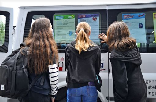 Drei junge Mädchen informieren sich über die Positionen der Parteien, bevor sie zur Wahl schreiten. Foto: /Karin Ait Atmane