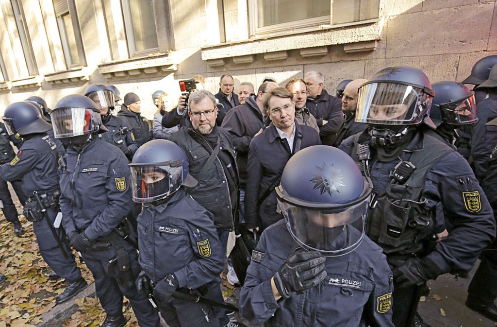 Oliver Hilburger, Kopf des Zentrums Automobil (Mitte), und Mitstreiter werden von Polizisten abgeschirmt.Foto: LichtgutLeif Piechowski