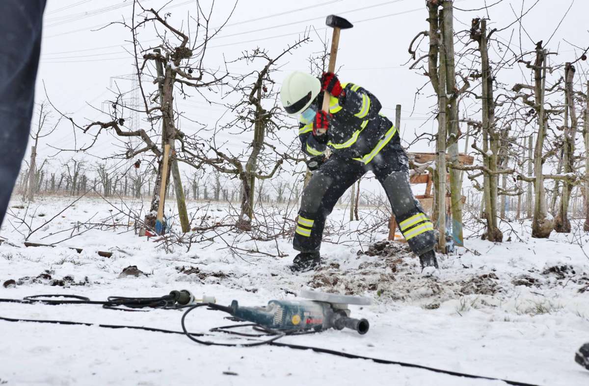 Schweißtreibender Einsatz in Weinstadt:  ein Feuerwehrmann legt das Rohr frei, in dem ein Hund feststeckt.